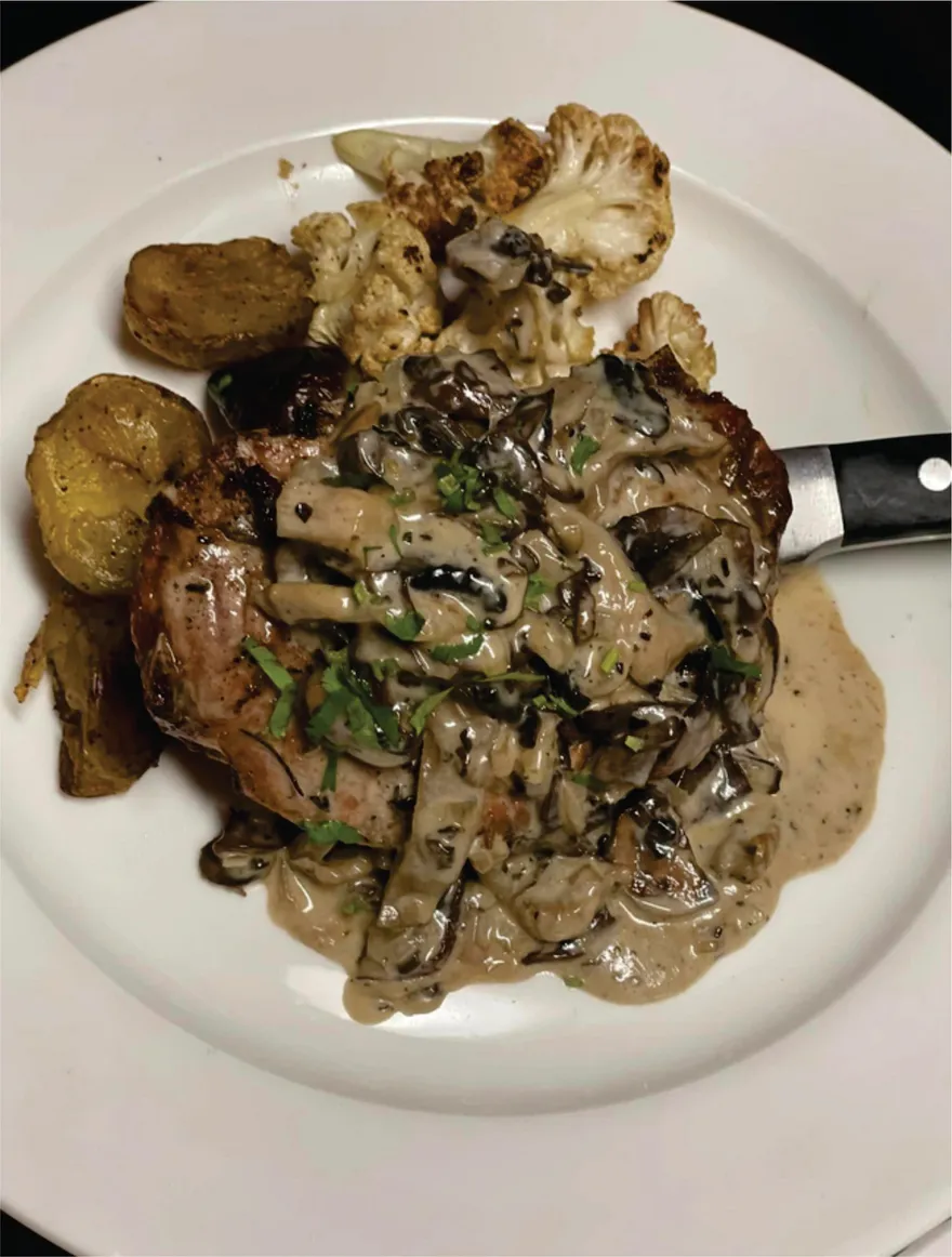 Grilled pork chop with porcini mushrooms in brandy cream