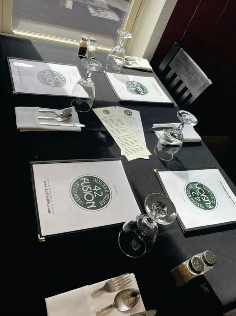A set table at 42 Fusion with menus and glassware